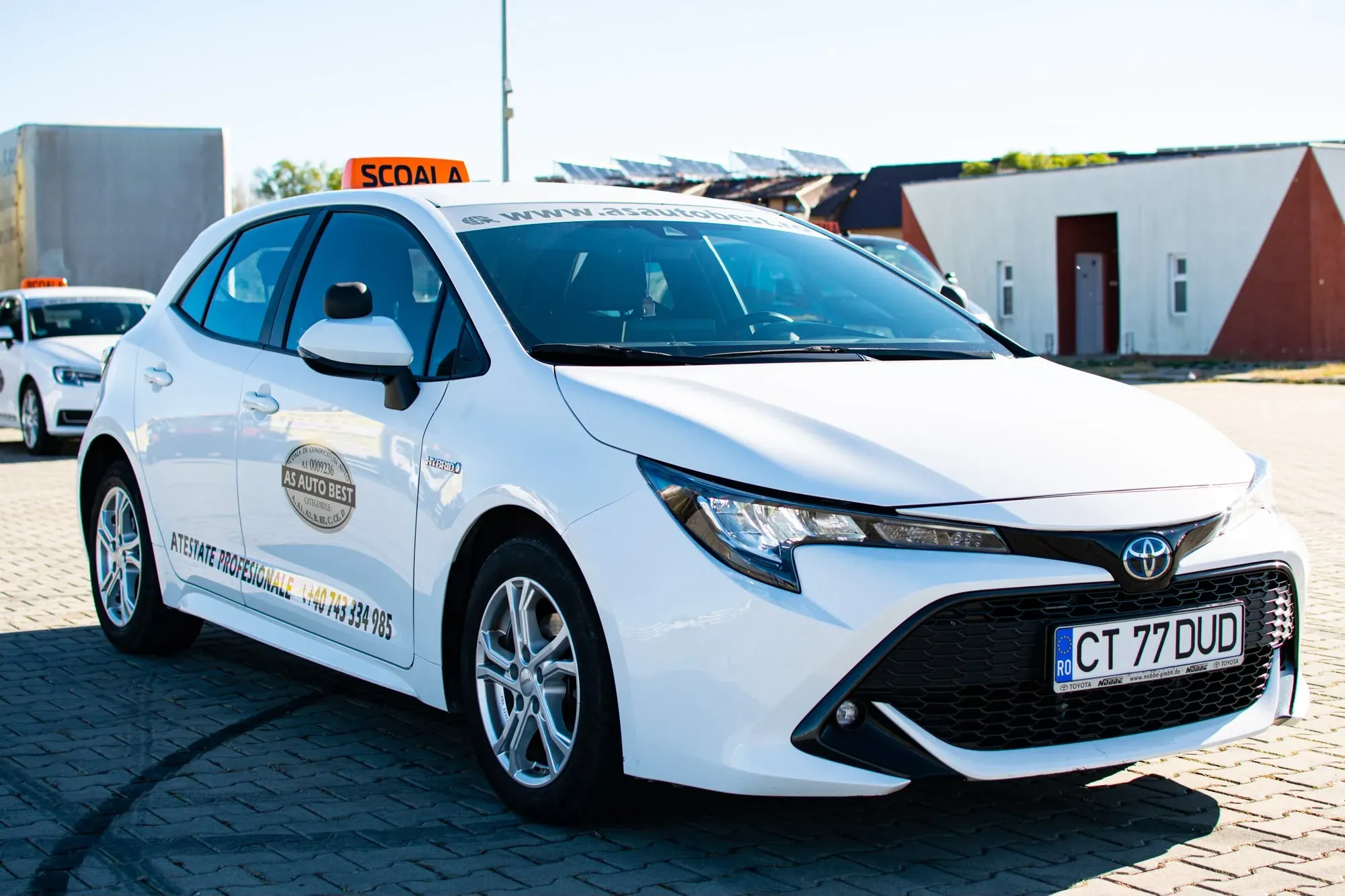 Toyota Corolla Hybrid albă folosită pentru permisul categoria B